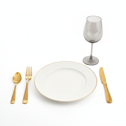Luxury close-up place setting with gold flatware, smoky wine glass and elegant dinner plate on white background